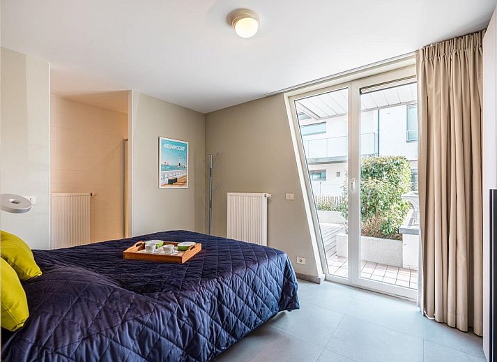 Moderne keuken in Tinou Gelijkvloers vakantiehuis in Koksijde, West-Vlaanderen, met strakke witte kasten en ruime werkbladen.