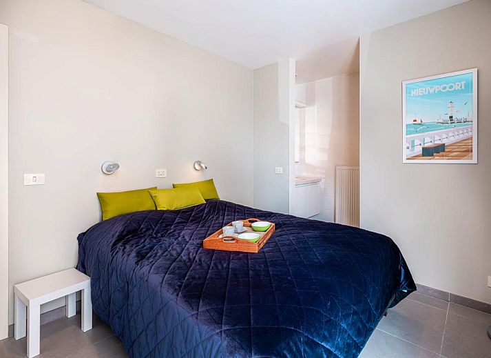 Moderne keuken in Tinou Gelijkvloers vakantiehuis in Koksijde, West-Vlaanderen, met strakke witte kasten en ruime werkbladen.