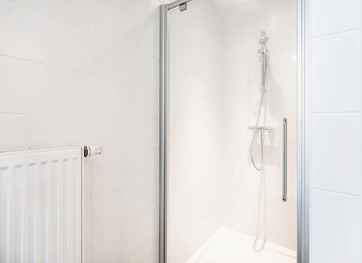 Moderne keuken in Tinou Gelijkvloers vakantiehuis in Koksijde, West-Vlaanderen, met strakke witte kasten en ruime werkbladen.