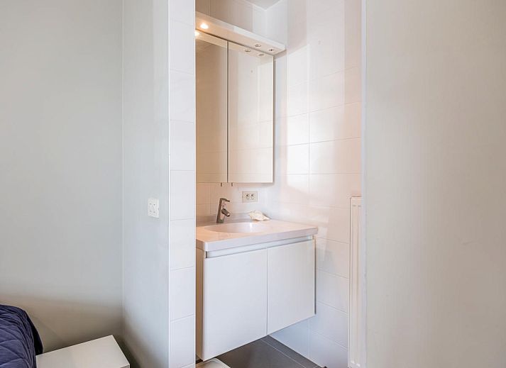 Moderne keuken in Tinou Gelijkvloers vakantiehuis in Koksijde, West-Vlaanderen, met strakke witte kasten en ruime werkbladen.