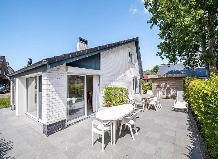 Ruim terras bij vakantiehuis Guillaume in Koksijde, West-Vlaanderen, Belgie, omgeven door groen en voorzien van comfortabele zitgelegenheden.
