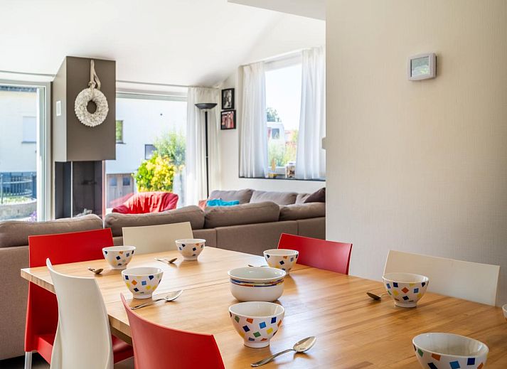 Ruim terras bij vakantiehuis Guillaume in Koksijde, West-Vlaanderen, Belgie, omgeven door groen en voorzien van comfortabele zitgelegenheden.