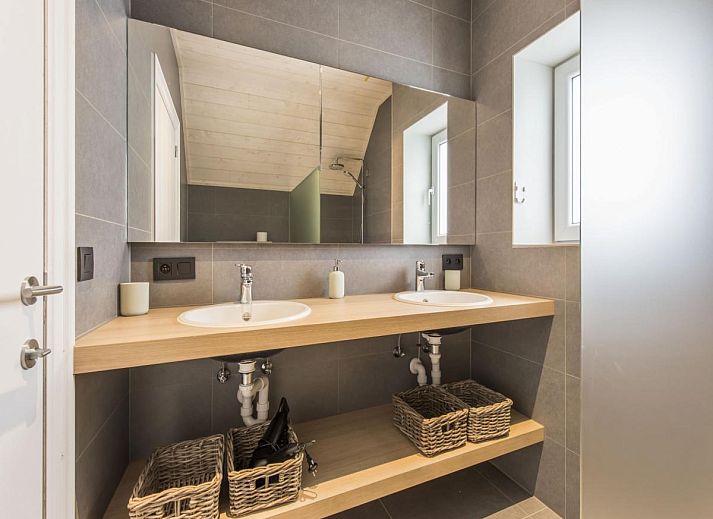 Stylish living room of vacation home La Vachequirit in Koksijde, West Flanders with comfortable seating area and large windows for plenty of light.