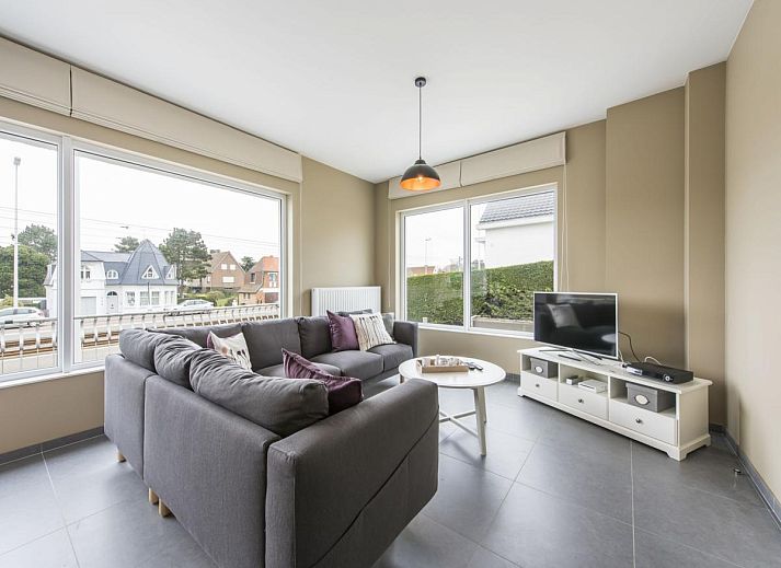 Stylish living room of vacation home La Vachequirit in Koksijde, West Flanders with comfortable seating area and large windows for plenty of light.