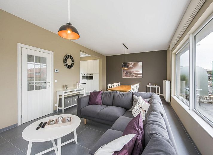 Stylish living room of vacation home La Vachequirit in Koksijde, West Flanders with comfortable seating area and large windows for plenty of light.