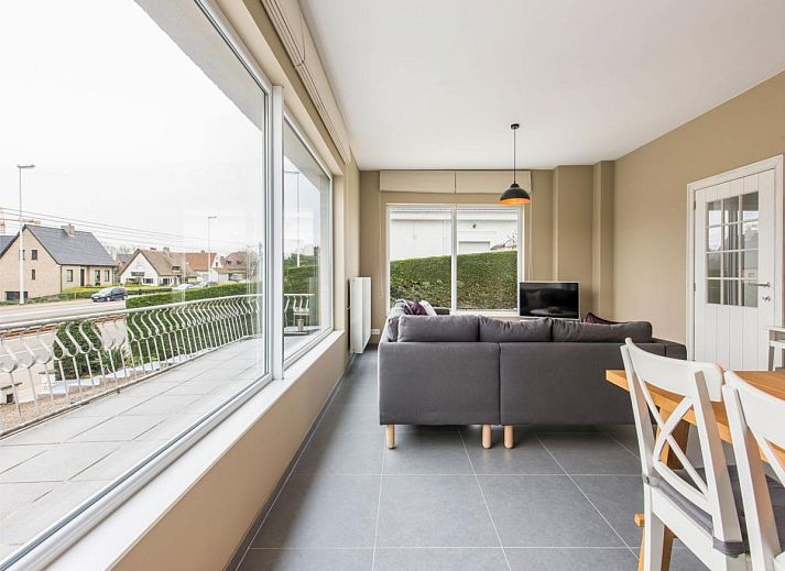 Dining room of vacation home La Vachequirit in Koksijde, West Flanders, with large table and view of the peaceful surroundings.