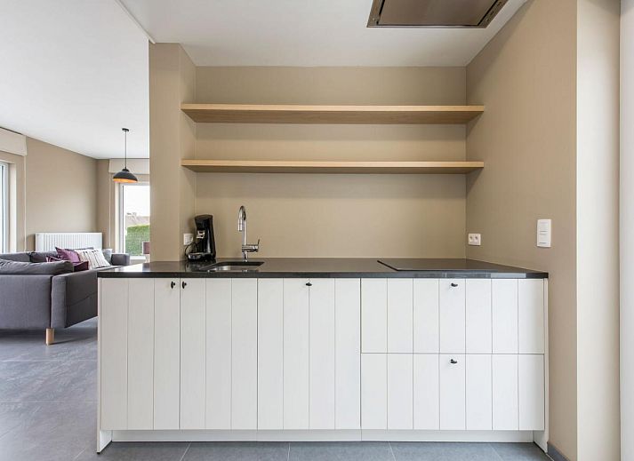 Dining room of vacation home La Vachequirit in Koksijde, West Flanders, with large table and view of the peaceful surroundings.