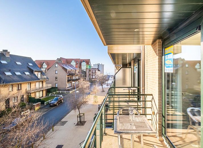 Geniet van het zonovergoten balkon van vakantiehuis Pablito trois in Koksijde, West-Vlaanderen, met uitzicht op de rustige straat.