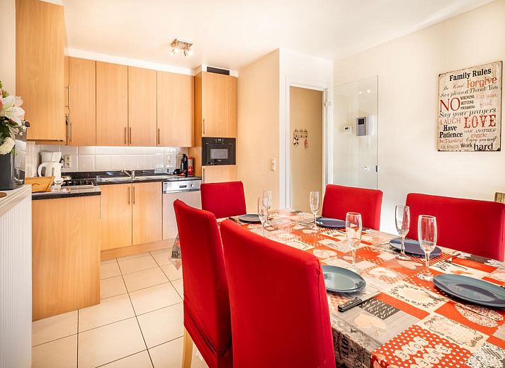 Gezellige eetkamer in vakantiehuis Pablito trois in Koksijde, West-Vlaanderen, met uitzicht op balkon en moderne inrichting.
