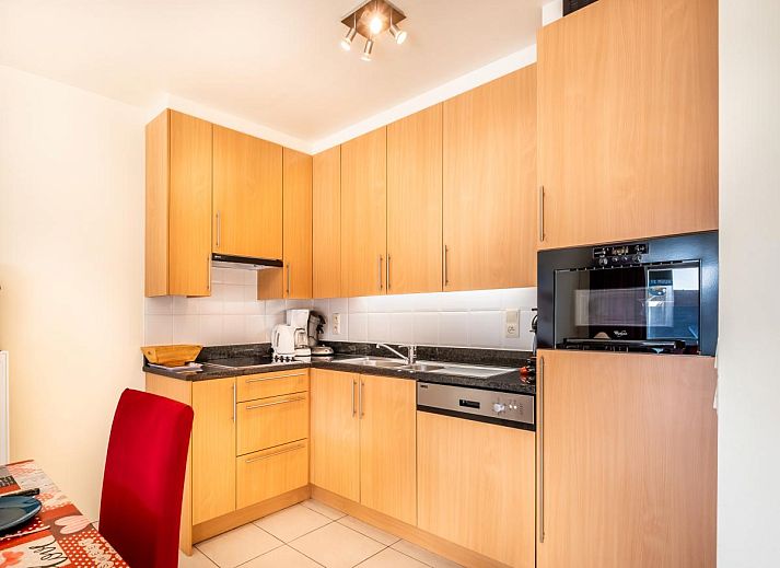 Gezellige eetkamer in vakantiehuis Pablito trois in Koksijde, West-Vlaanderen, met uitzicht op balkon en moderne inrichting.