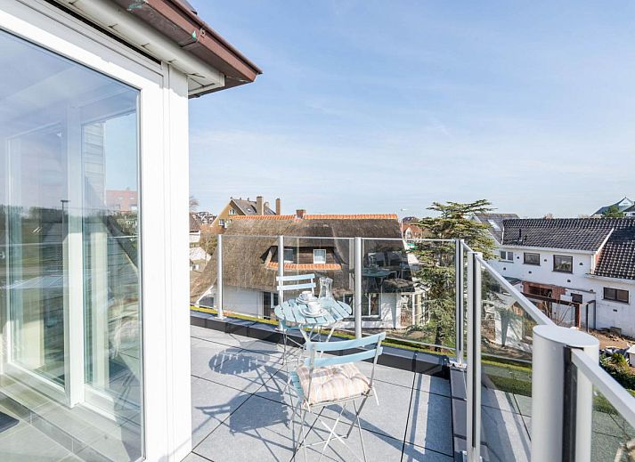 Lichte woonkamer van Bon Accueil tweede vakantiehuis in Koksijde, West-Vlaanderen, met moderne inrichting en uitzicht op het terras.