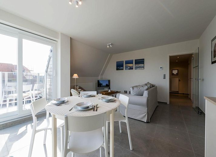 Lichte woonkamer van Bon Accueil tweede vakantiehuis in Koksijde, West-Vlaanderen, met moderne inrichting en uitzicht op het terras.