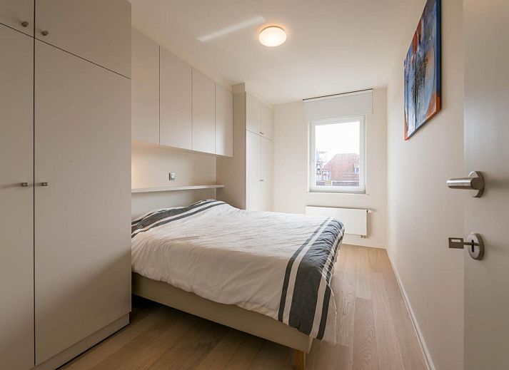 Lichte woonkamer van Bon Accueil tweede vakantiehuis in Koksijde, West-Vlaanderen, met moderne inrichting en uitzicht op het terras.