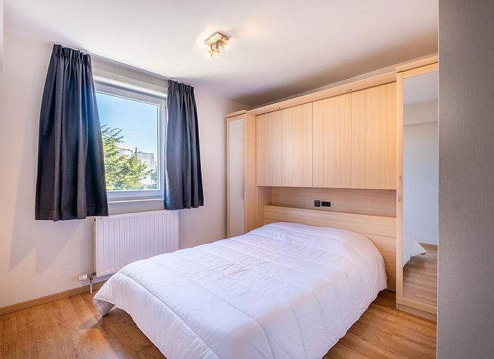 Ruime eetkamer en keuken in vakantiehuis Paco Vierde, Koksijde, West-Vlaanderen. Gezellige binnenruimte met moderne inrichting en kunstwerk.