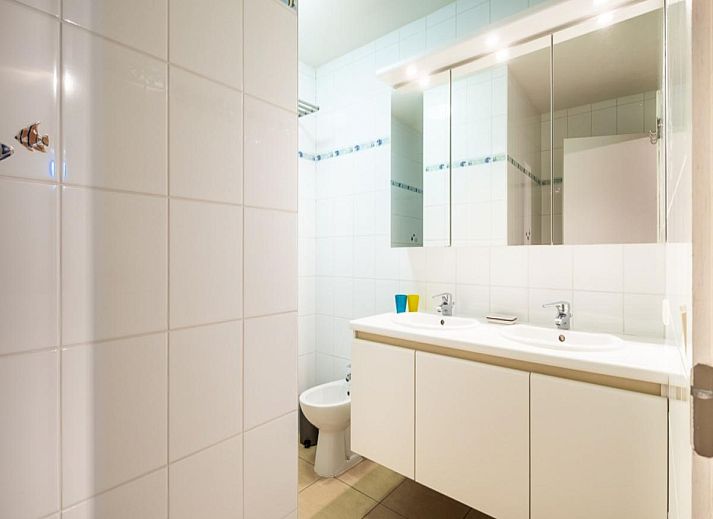 Ruime eetkamer en keuken in vakantiehuis Paco Vierde, Koksijde, West-Vlaanderen. Gezellige binnenruimte met moderne inrichting en kunstwerk.