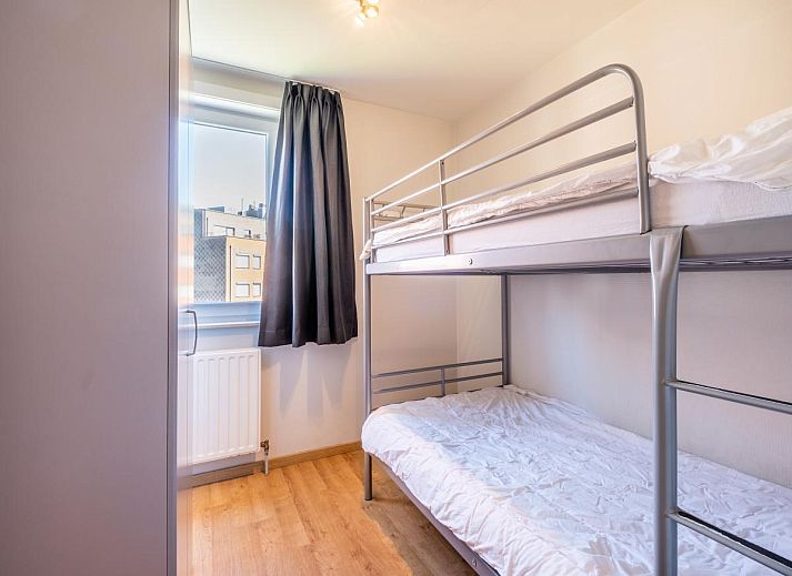 Ruime eetkamer en keuken in vakantiehuis Paco Vierde, Koksijde, West-Vlaanderen. Gezellige binnenruimte met moderne inrichting en kunstwerk.