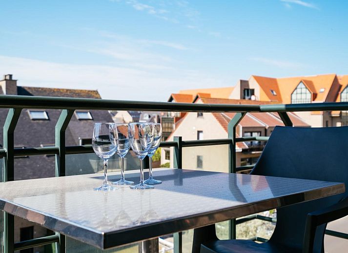 Ruime eetkamer en keuken in vakantiehuis Paco Vierde, Koksijde, West-Vlaanderen. Gezellige binnenruimte met moderne inrichting en kunstwerk.