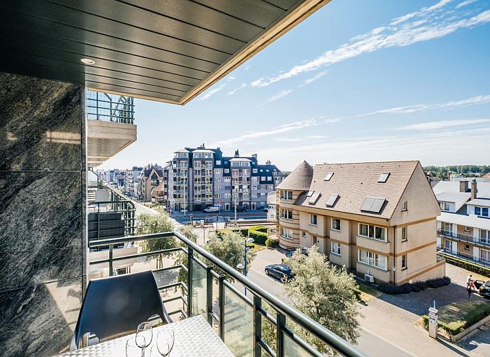 Moderne keuken in vakantiehuis Paco vierde, Koksijde, West-Vlaanderen. Ruime binnenruimte met houten kasten en tegelvloer.