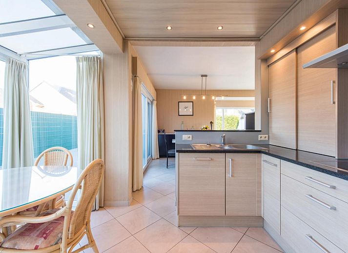 Gezellige woonkamer in vakantiehuis Mallory, Koksijde, met comfortabele banken en veel natuurlijk licht, ideaal voor ontspanning in West-Vlaanderen.