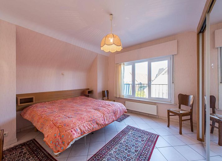 Gezellige woonkamer in vakantiehuis Mallory, Koksijde, met comfortabele banken en veel natuurlijk licht, ideaal voor ontspanning in West-Vlaanderen.