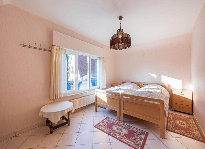 Gezellige woonkamer in vakantiehuis Mallory, Koksijde, met comfortabele banken en veel natuurlijk licht, ideaal voor ontspanning in West-Vlaanderen.