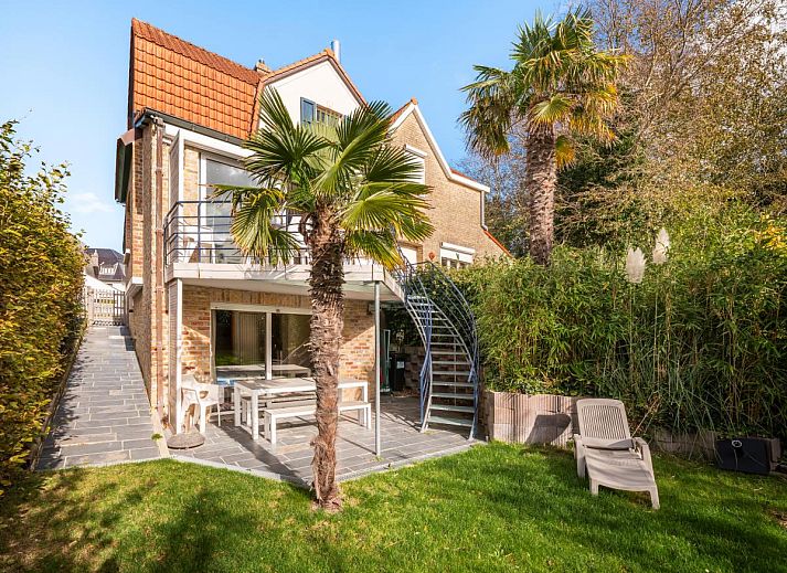 Le Palmier vakantiehuis in Koksijde, West-Vlaanderen met zonnig terras, omgeven door palmbomen en groene tuin, ideaal voor ontspanning.