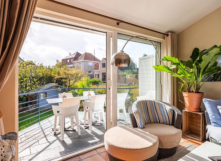 Ruime eetkamer in vakantiehuis Le Palmier in Koksijde, West-Vlaanderen, met uitzicht op tuin en comfortabele inrichting.