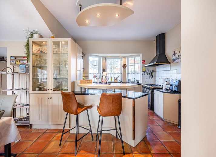 Ruime eetkamer in vakantiehuis Le Palmier in Koksijde, West-Vlaanderen, met uitzicht op tuin en comfortabele inrichting.