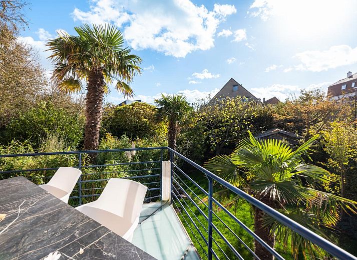 Ruime eetkamer in vakantiehuis Le Palmier in Koksijde, West-Vlaanderen, met uitzicht op tuin en comfortabele inrichting.