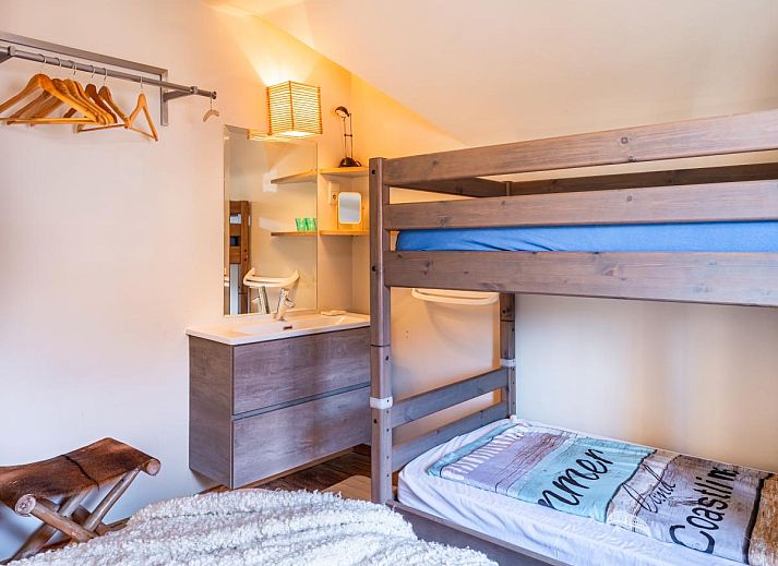 Gezellige woonkamer van vakantiehuis Le Palmier in Koksijde, West-Vlaanderen, met eethoek en uitzicht op de tuin.