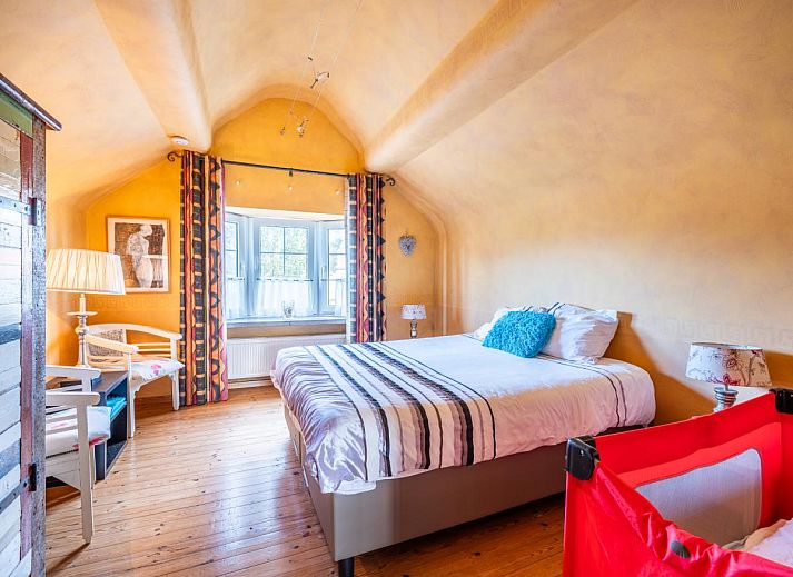 Gezellige woonkamer van vakantiehuis Le Palmier in Koksijde, West-Vlaanderen, met eethoek en uitzicht op de tuin.