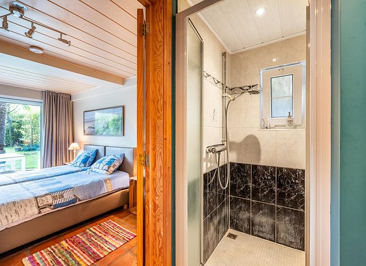 Gezellige woonkamer van vakantiehuis Le Palmier in Koksijde, West-Vlaanderen, met eethoek en uitzicht op de tuin.