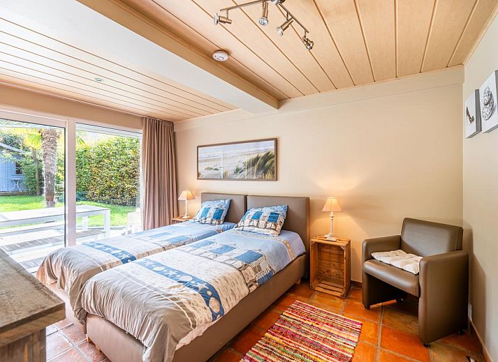 Gezellige woonkamer in vakantiehuis Le Palmier in Koksijde, West-Vlaanderen, met comfortabele zithoek en veel natuurlijk licht.