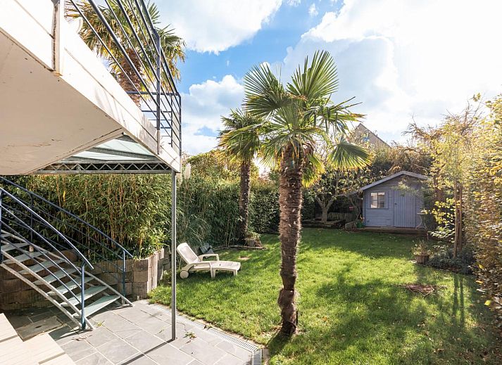 Gezellige woonkamer in vakantiehuis Le Palmier in Koksijde, West-Vlaanderen, met comfortabele zithoek en veel natuurlijk licht.