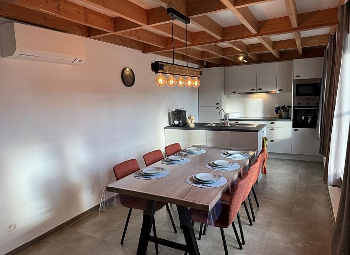 Gezellige eetkamer en keuken in vakantiehuis Westhinder II H23, Koksijde, West-Vlaanderen, met moderne inrichting en uitzicht op de tuin.