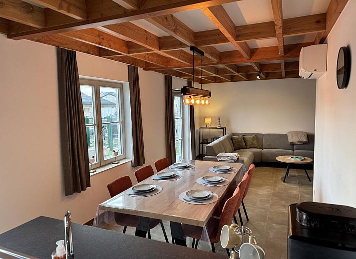 Gezellige eetkamer en keuken in vakantiehuis Westhinder II H23, Koksijde, West-Vlaanderen, met moderne inrichting en uitzicht op de tuin.