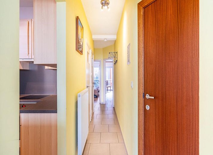 Gezellige woonkamer in vakantiehuis Vitelli, Koksijde, West-Vlaanderen. Comfortabele zithoek met moderne inrichting en kunst aan de muur.