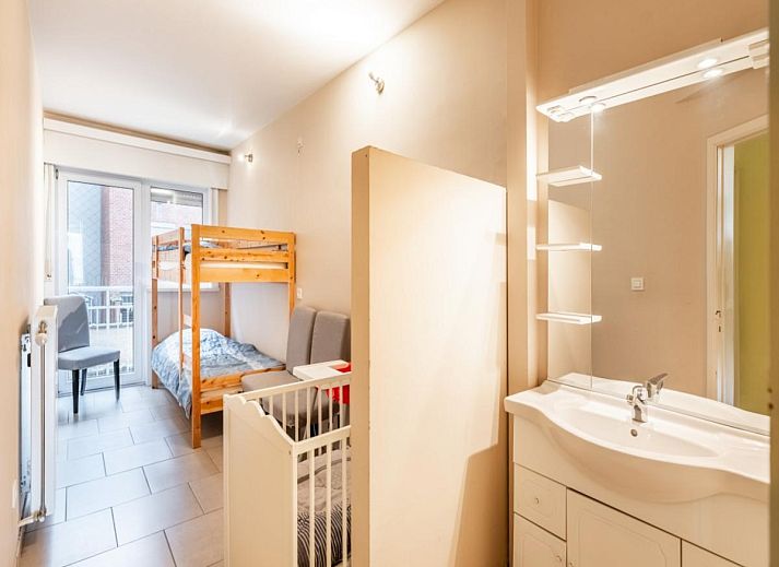 Gezellige woonkamer in vakantiehuis Vitelli, Koksijde, West-Vlaanderen. Comfortabele zithoek met moderne inrichting en kunst aan de muur.