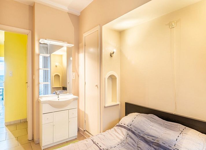 Gezellige woonkamer in vakantiehuis Vitelli, Koksijde, West-Vlaanderen. Comfortabele zithoek met moderne inrichting en kunst aan de muur.