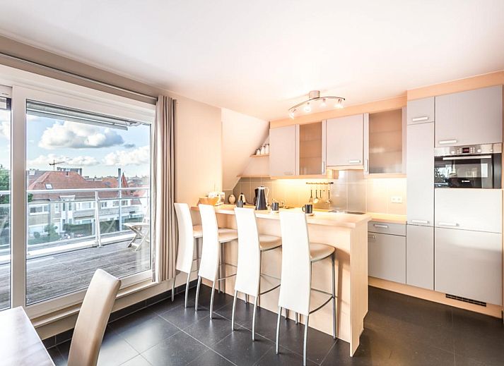 Ruime eetkamer van Le Penthouse in Koksijde, West-Vlaanderen met uitzicht op het terras en moderne inrichting.
