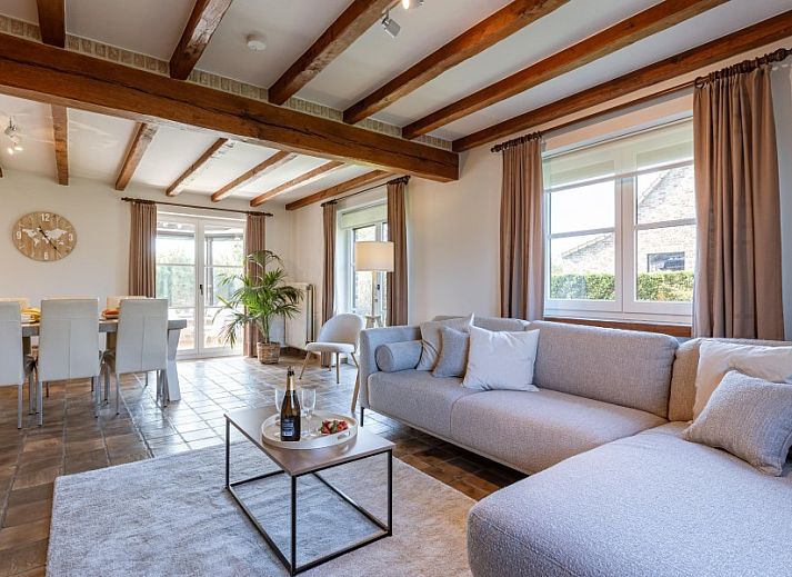 Gemuetliches Wohnzimmer in der Villa Florentine, einem Ferienhaus in Oostduinkerke, Westflandern, mit Holzbalken und bequemer Sitzecke.