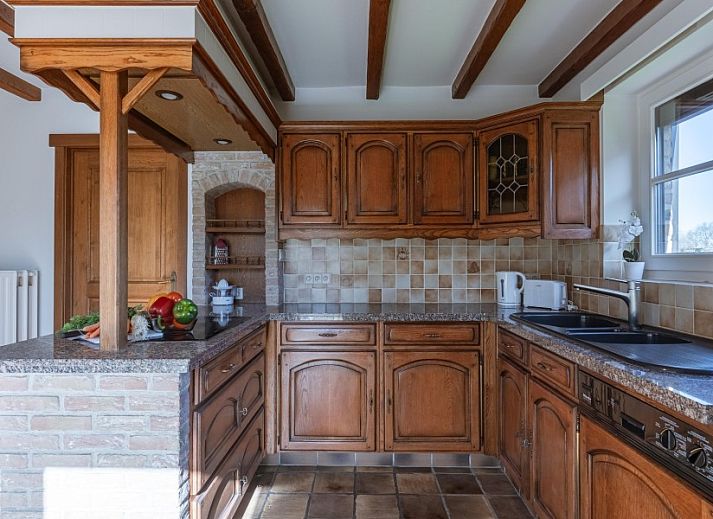 Gemuetliches Wohnzimmer in der Villa Florentine, einem Ferienhaus in Oostduinkerke, Westflandern, mit Holzbalken und bequemer Sitzecke.