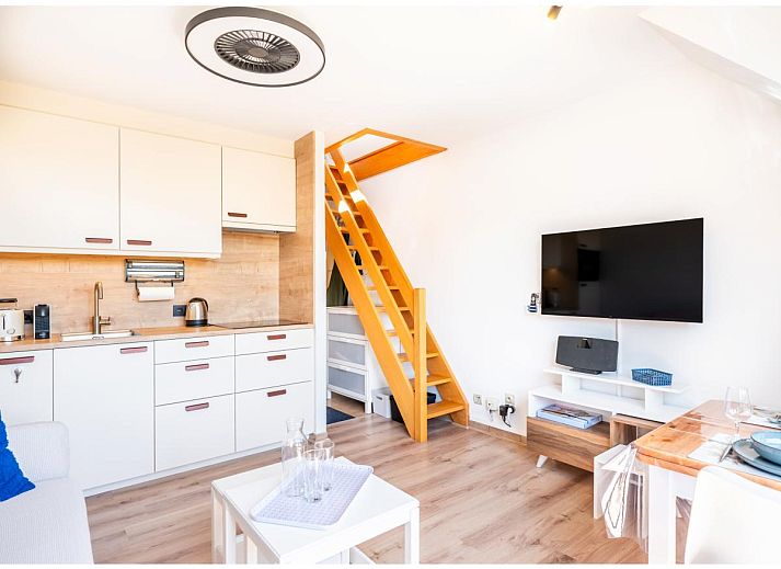 Lichte woonkamer van Ardoise des dunes vakantiehuis in Koksijde, West-Vlaanderen, met uitzicht op groene omgeving.
