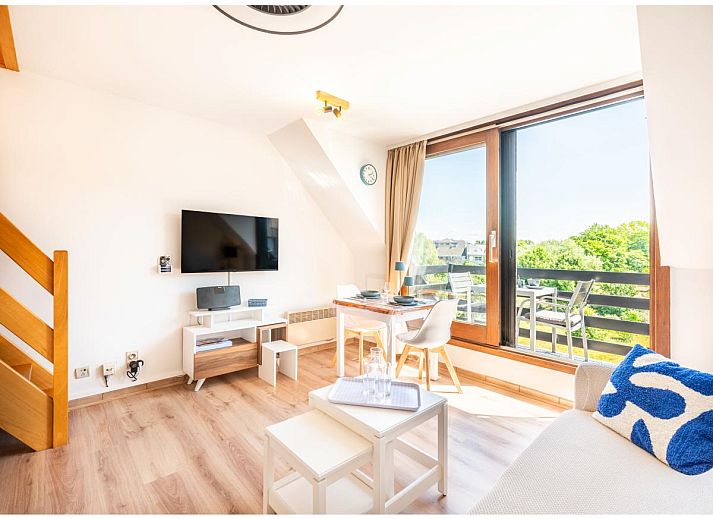 Veranda van Ardoise des dunes vakantiehuis in Koksijde, West-Vlaanderen, met prachtig uitzicht op groene omgeving.