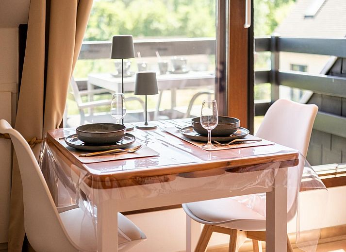 Lichte woonkamer van Ardoise des dunes vakantiehuis in Koksijde, met uitzicht op groen vanaf het balkon, West-Vlaanderen, Belgie.