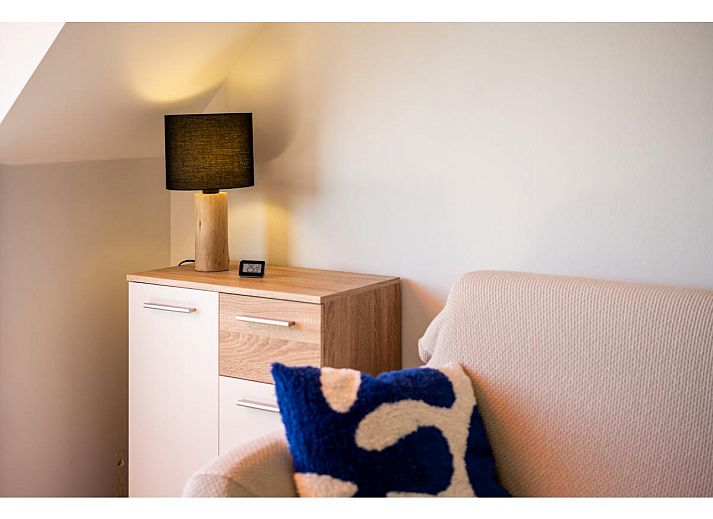 Lichte woonkamer van Ardoise des dunes vakantiehuis in Koksijde, met uitzicht op groen vanaf het balkon, West-Vlaanderen, Belgie.