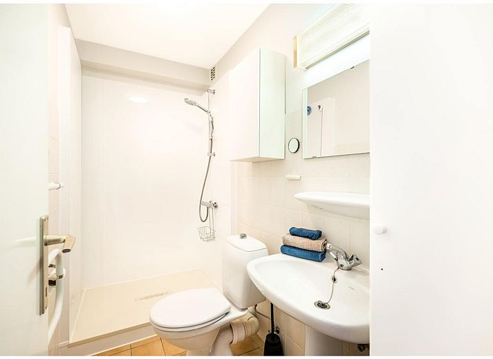 Lichte woonkamer van Ardoise des dunes vakantiehuis in Koksijde, met uitzicht op groen vanaf het balkon, West-Vlaanderen, Belgie.