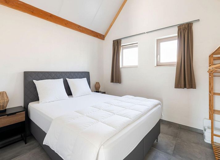 Moderne keuken en eetruimte in vakantiehuis Westhinder I H12, Koksijde, met houten balken en veel lichtinval.