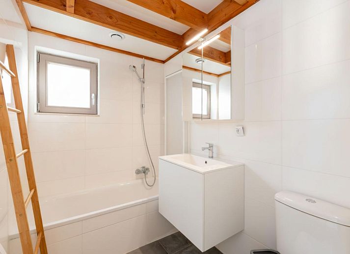 Moderne keuken en eetruimte in vakantiehuis Westhinder I H12, Koksijde, met houten balken en veel lichtinval.