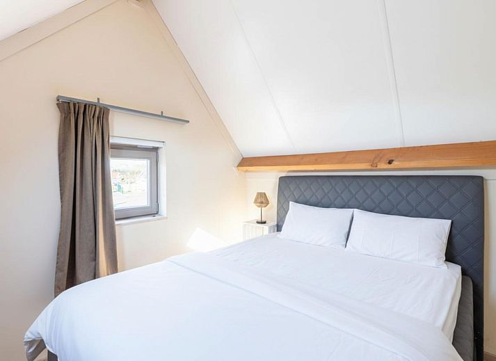 Moderne keuken en eetruimte in vakantiehuis Westhinder I H12, Koksijde, met houten balken en veel lichtinval.